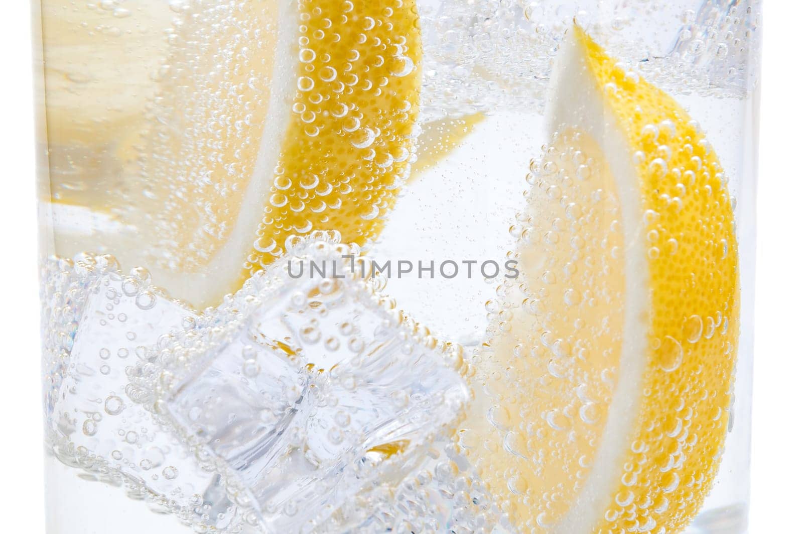 In a glass with cubes of melting ice slices of a juicy lemon.