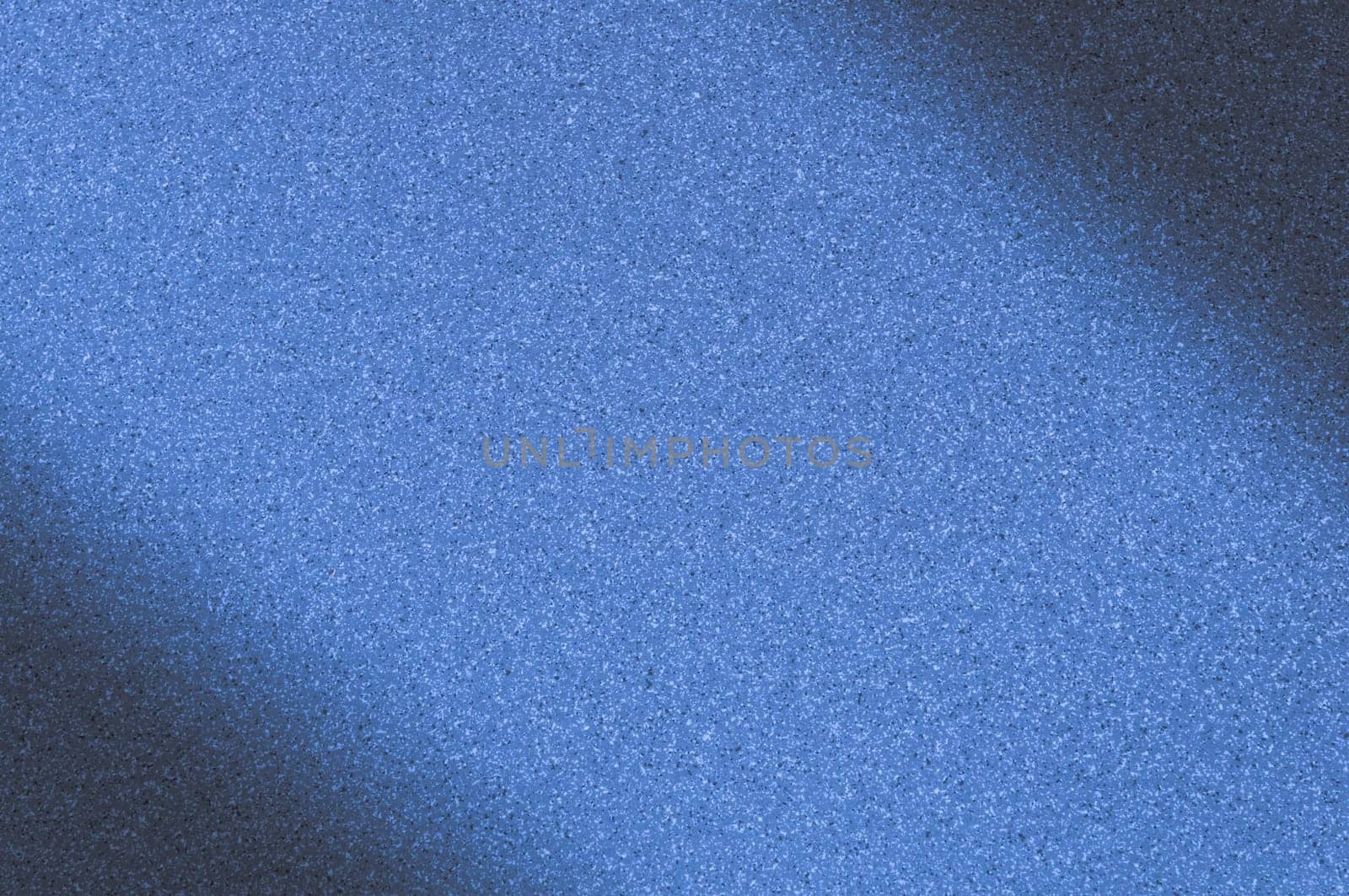 Granite background with blue color with small dots. Darkening left and right diagonally. Blurred.