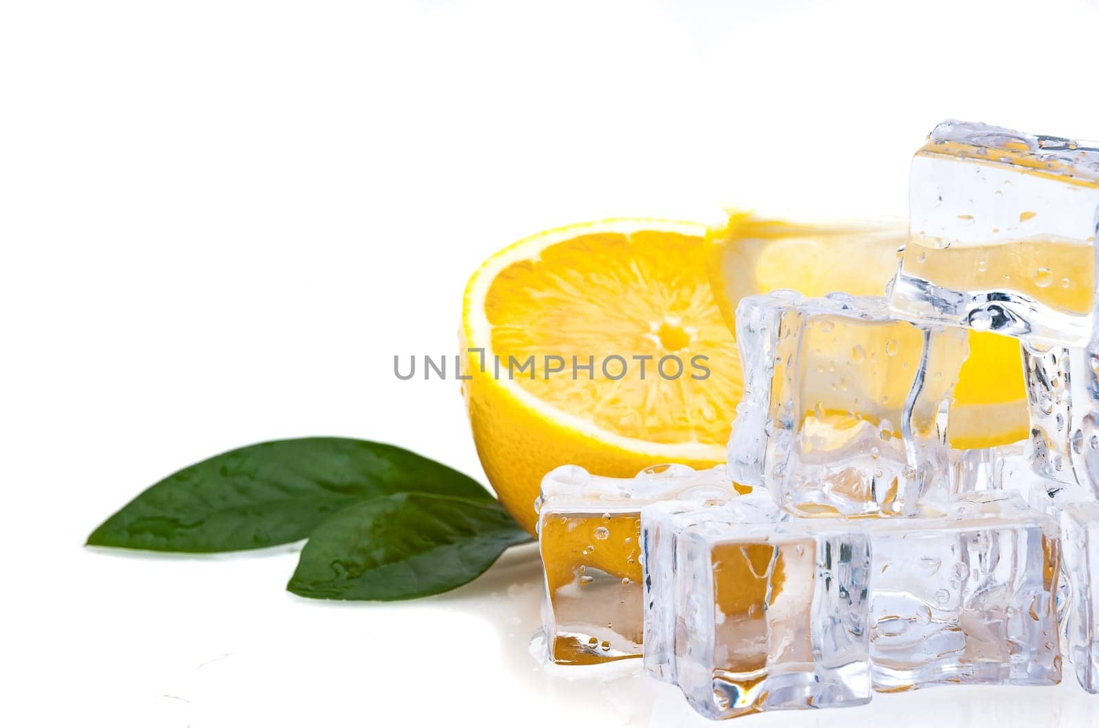 Half of a fresh, bright lemon with green leaves and cubes of cold ice, on a white background.