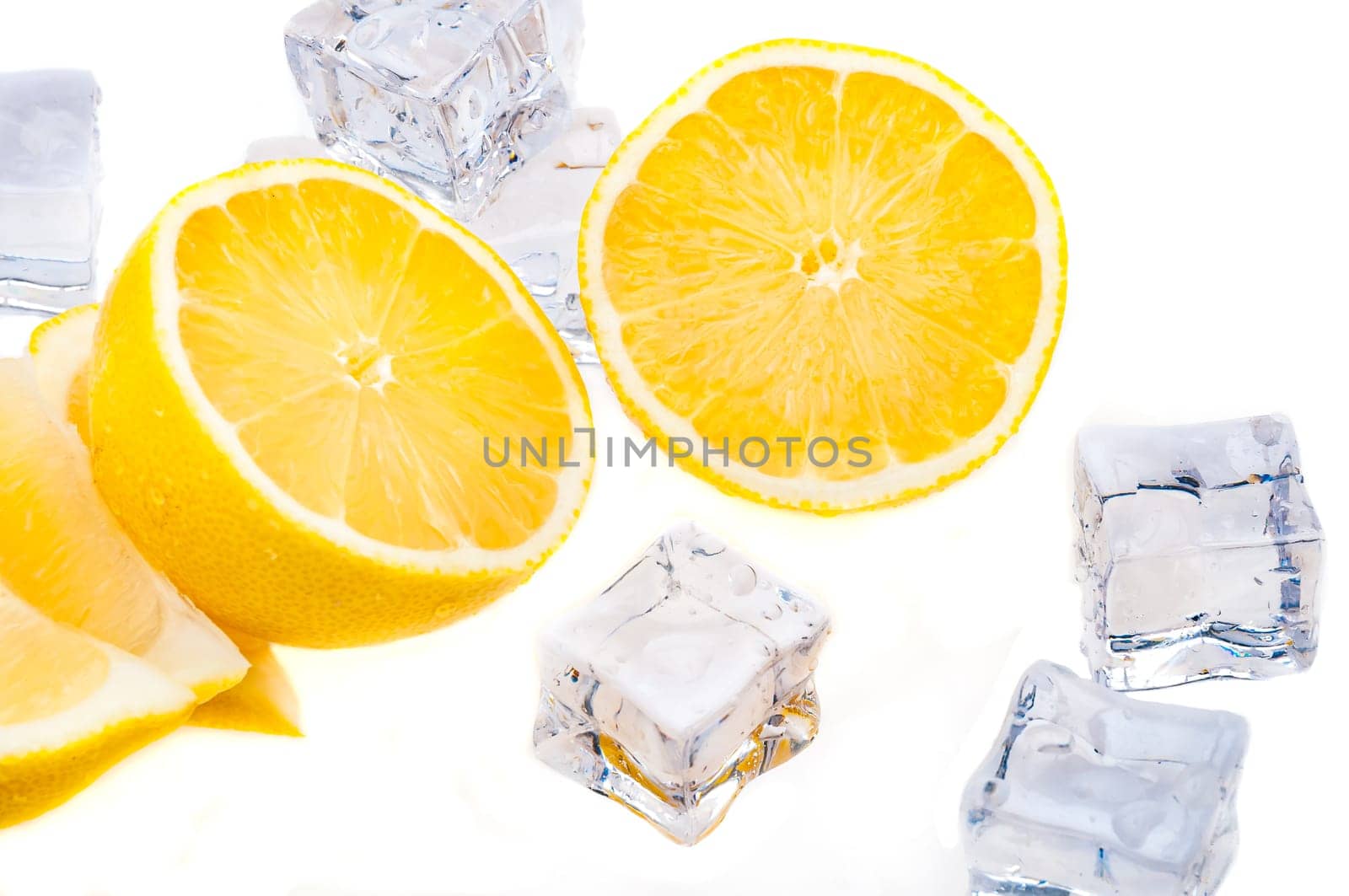 Cubes of cold ice, and halves of fresh, bright juicy lemon on a white background.