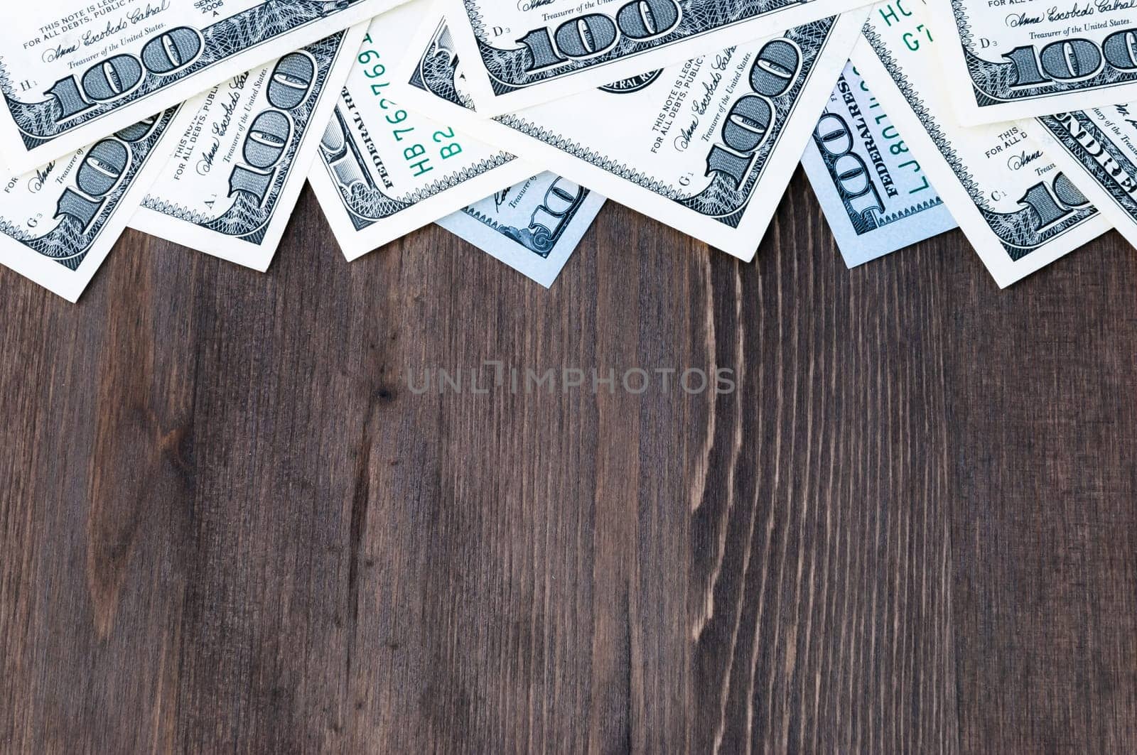 A frame of one hundred dollar bills at the top and a background of dark wood.