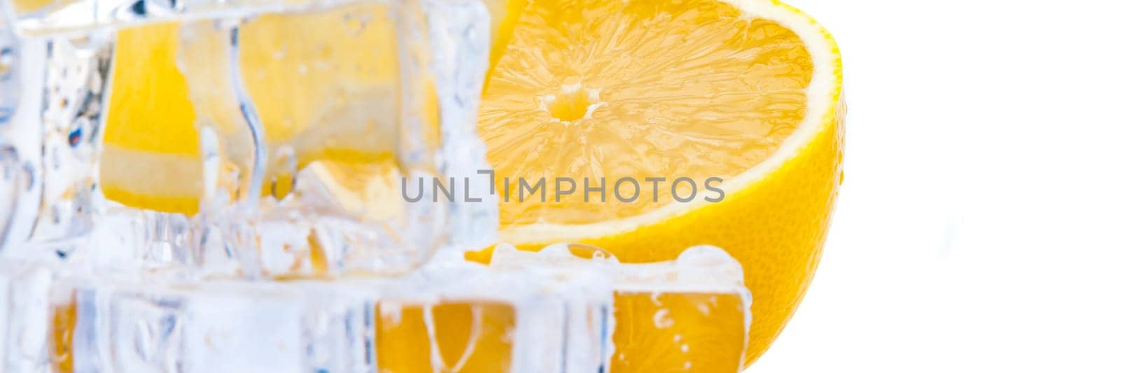 Cubes of cold ice, and halves of fresh, bright juicy lemon on a white background.