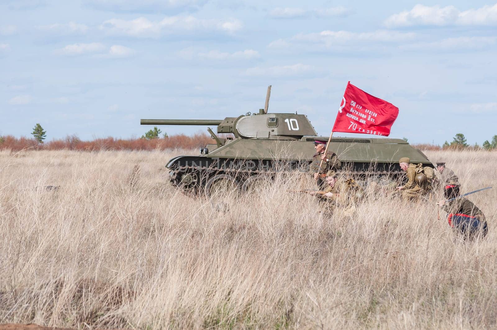 2018-04-30 The Samara, Russia. A commander with a banner leads into the battle of Soviet soldiers. Reconstruction of hostilities in April 1945.