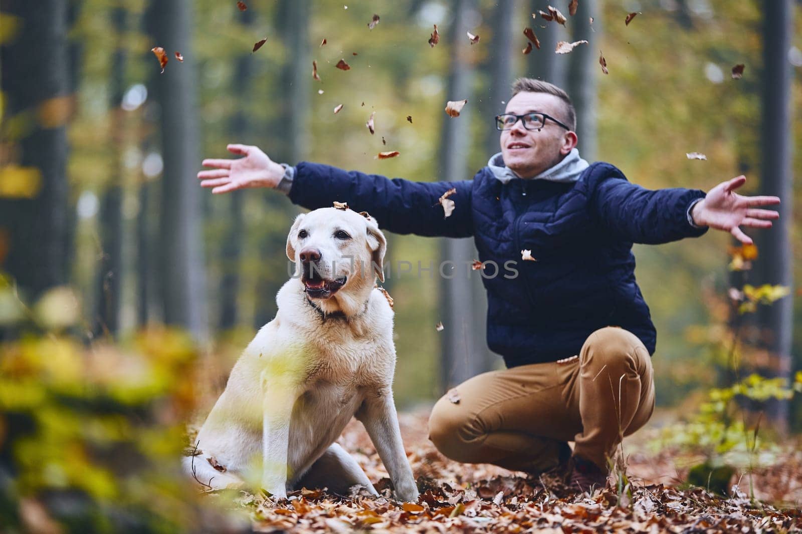 Man with dog in forest. Pet owner of labrador retriever enjoying from autumn.
