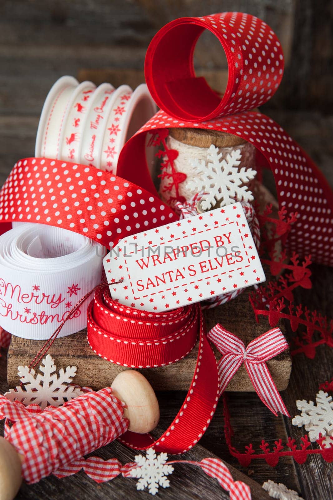 Cheerful ribbons for wrapping Christmas presents in front off wooden background