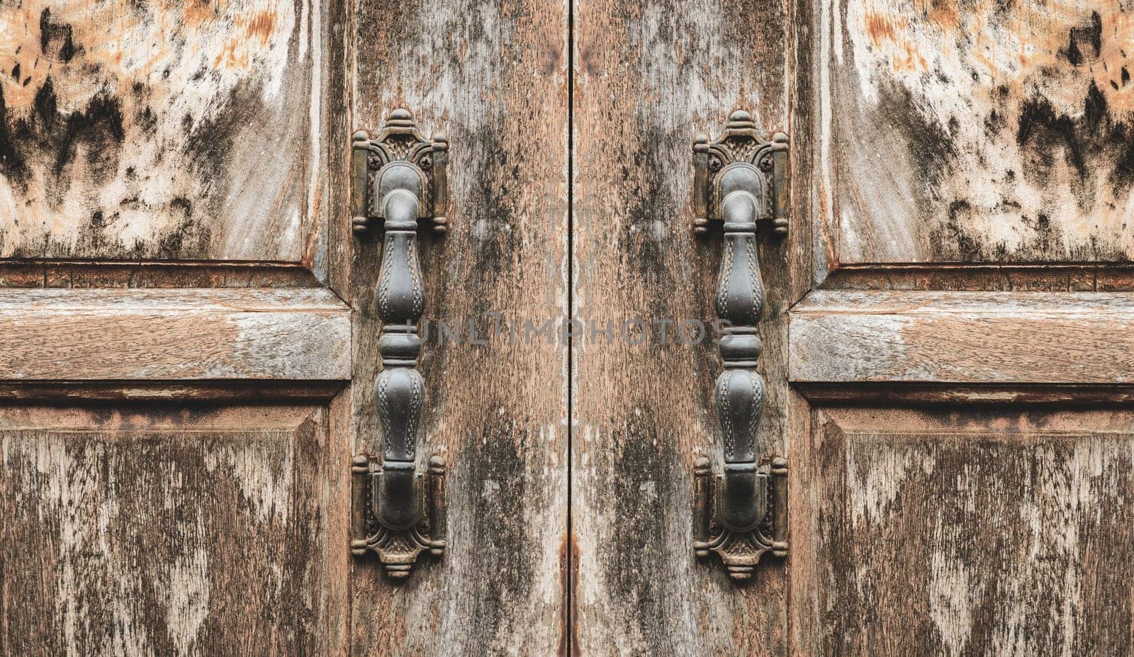 Antique door handle of grunge wooden door