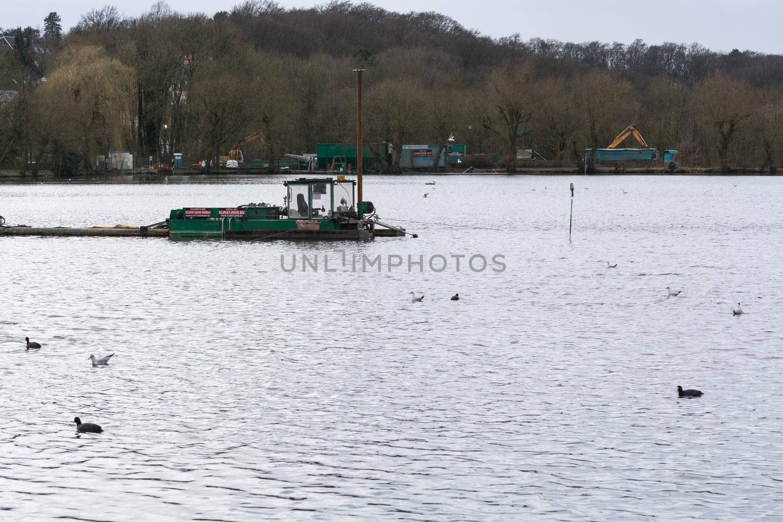HEILIGENHAUS, NRW, DEUTSCHLAND - MÄRZ 03, 2017:.Special ship, working platform in use on a small pond. Wet dredging at the Abtskuecher Teich in Heiligenhaus.