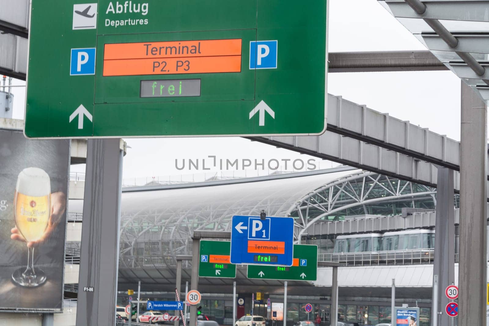 DUESSELDORF, NRW, GERMANY - FEBRUARY 20, 2017: Access road to the departure terminal of the airport Duesseldorf. Signposts and suspension railway and cars in the background.
