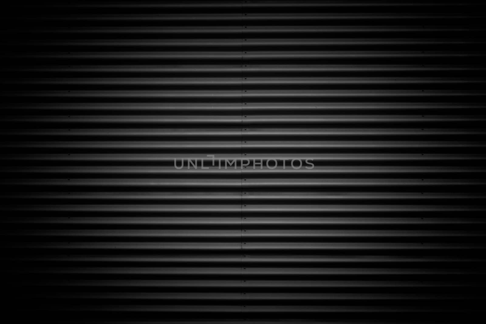Wide shot of dark corrugated metal with bolts. Vignette added