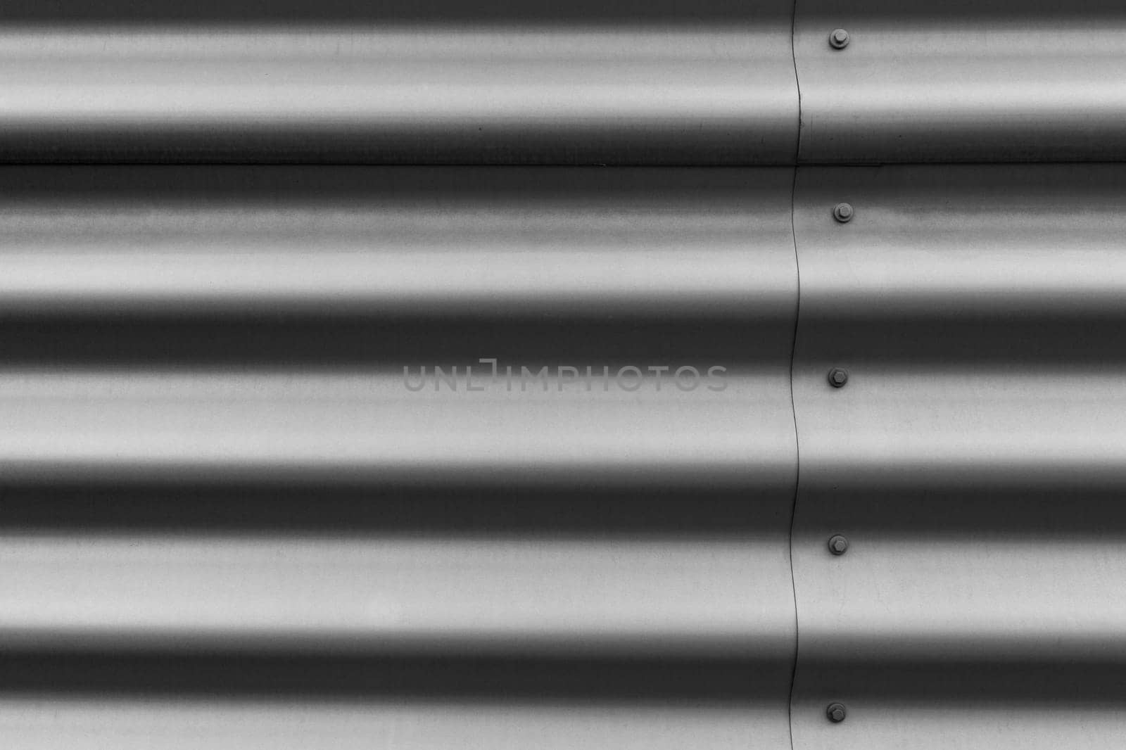 Detail of silver corrugated metal with bolts