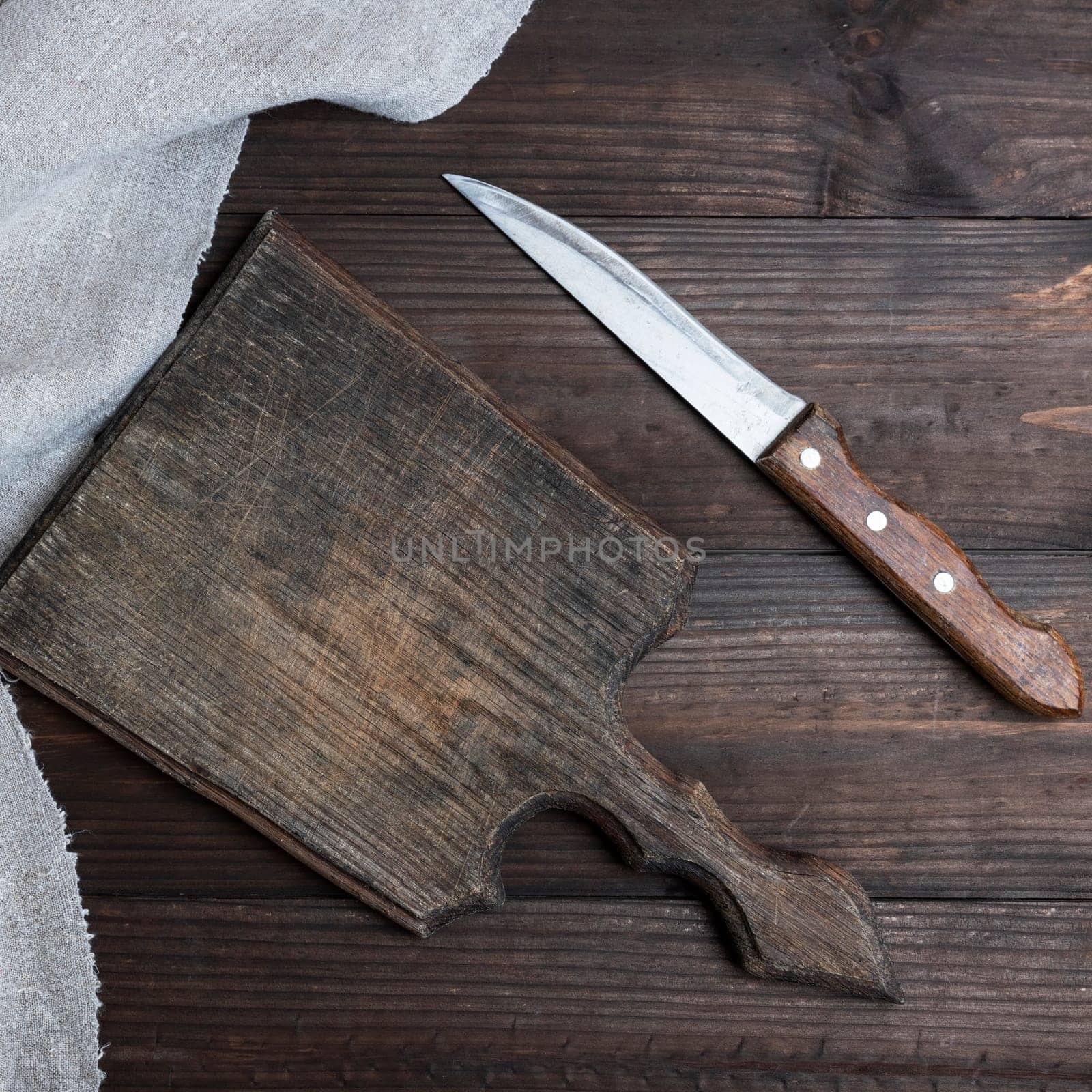 empty old brown wooden cutting board and knife on the table, top view
