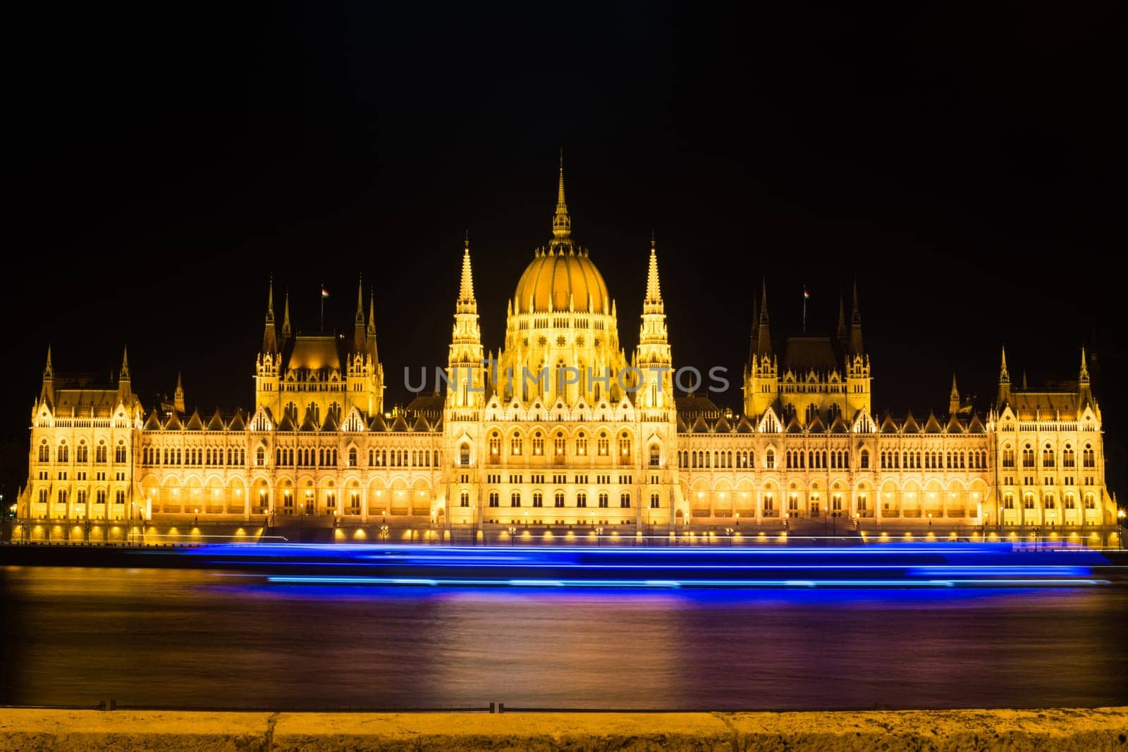 Landmark of Budapest Parliament at night on Danube with beautiful city lights.