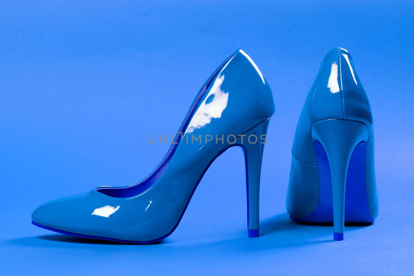 Sexy blue high heels shoes are on blue background.
