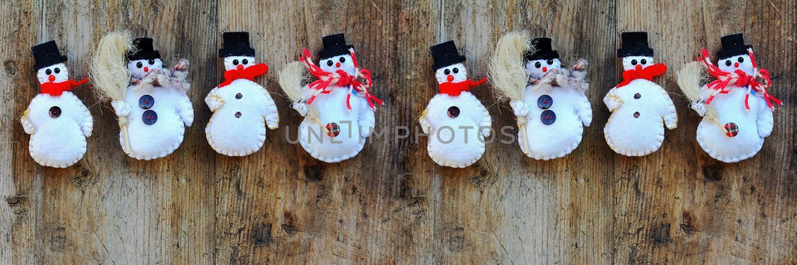 Four snowmen on a wooden background. Christmas background