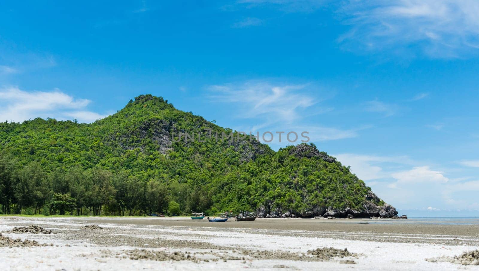 Rock or stone mountain or hill and blue sky and fishing boat at Sam Phraya beach Prachuap Khiri Khan Thailand. Landscape or scenery in .natural for summer concept