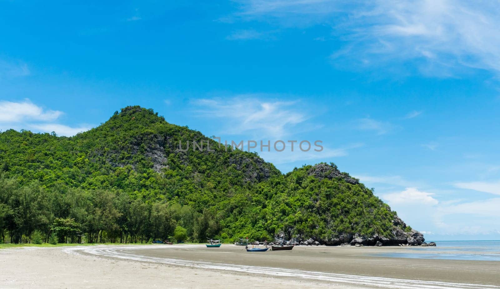 Rock or stone mountain or hill and blue sky and fishing boat at Sam Phraya beach Prachuap Khiri Khan Thailand. Landscape or scenery in .natural for summer concept