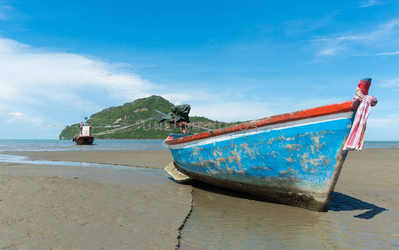 Blue fishing boat or fisherman boat or ship on Sam Roi Yod bech Prachuap Khiri Khan Thailand with blue sky and cloud and blue sea and .mountain or hill. Landscape or scenery for summer season concept