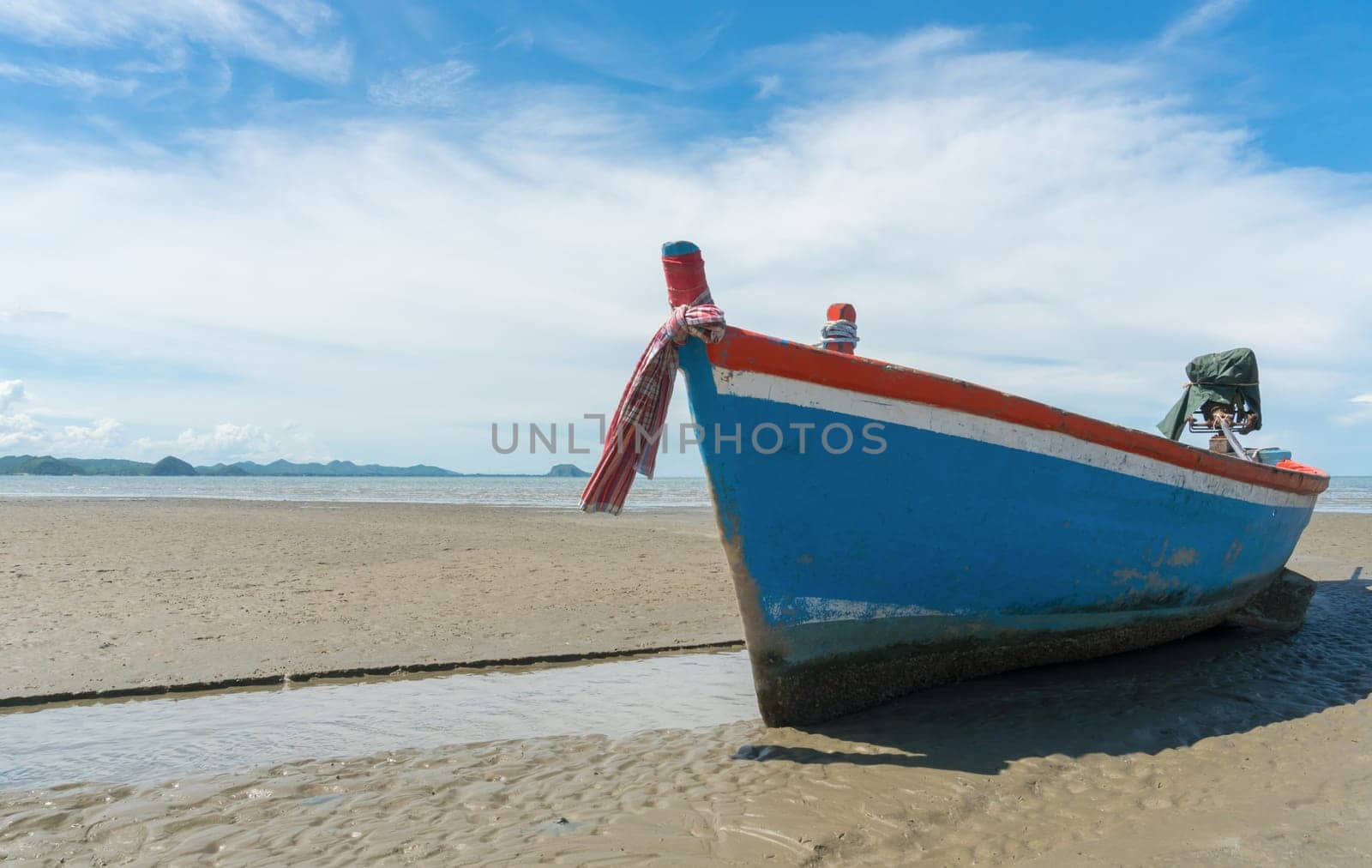 Blue fishing boat or fisherman boat or ship on Sam Roi Yod bech Prachuap Khiri Khan Thailand with blue sky and cloud and blue sea and .mountain or hill. Landscape or scenery for summer season concept