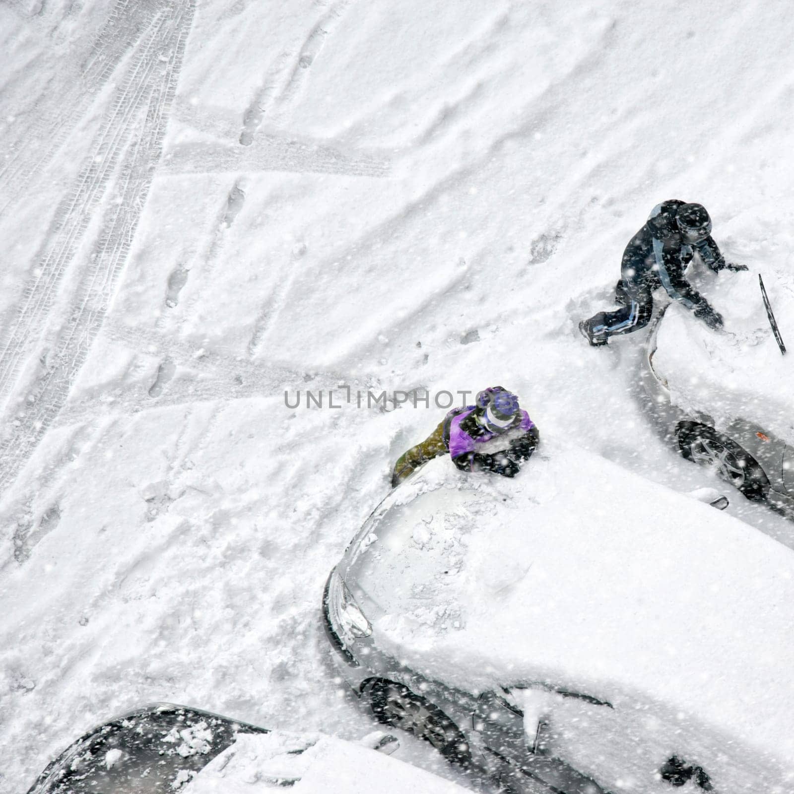 Elevated view of children play in snow covered parking lot