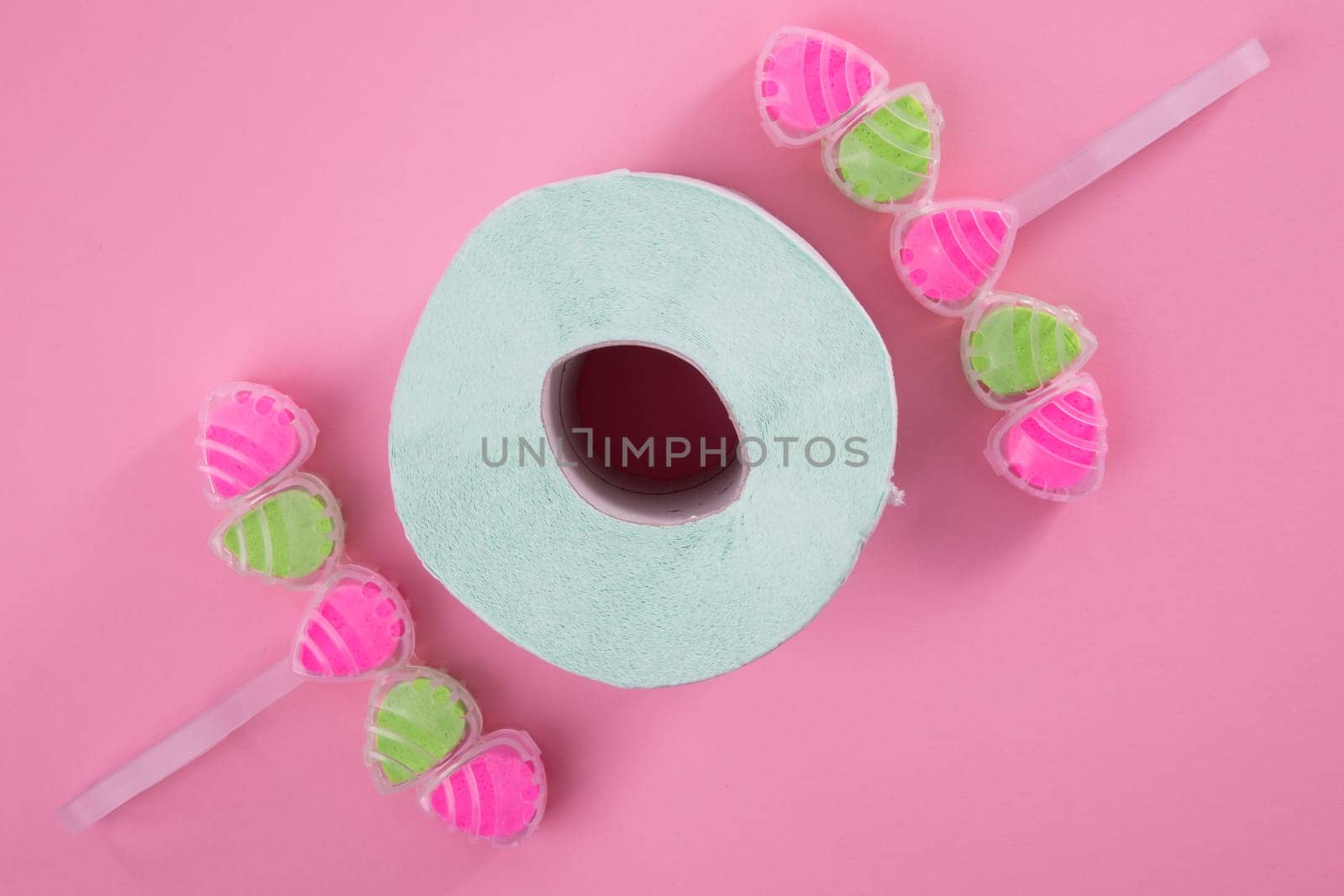 Sanitary Cleaner tablets with toilet paer on pink backround