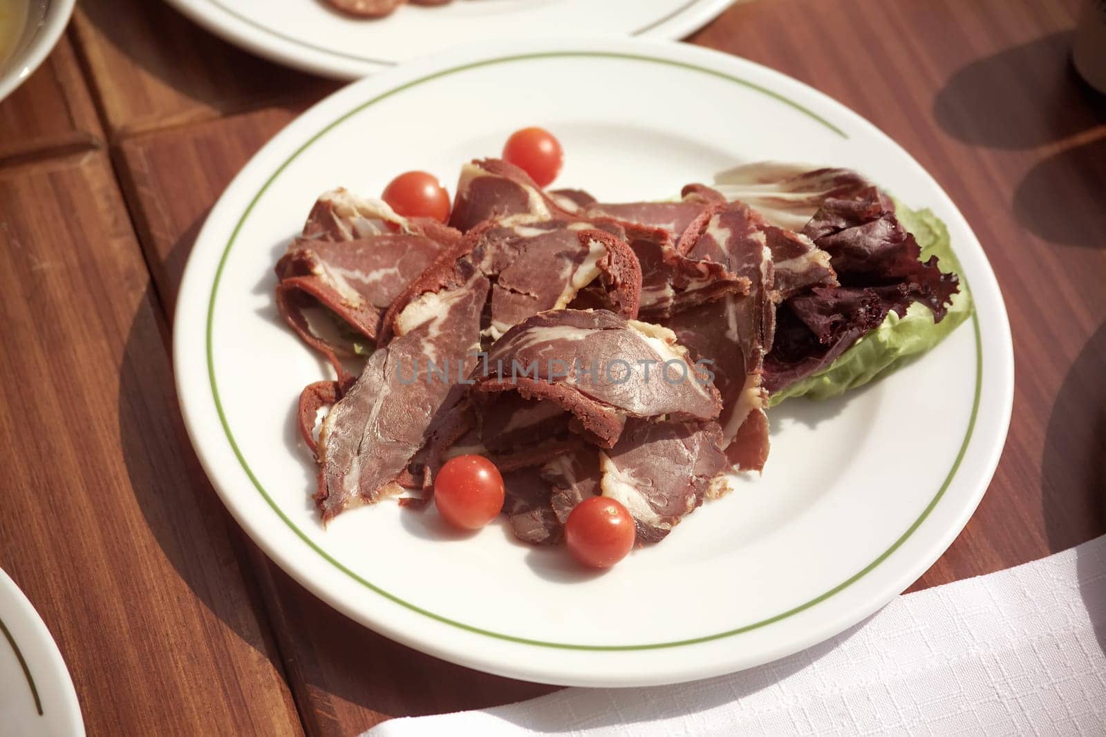 close up plate of sliced pastrami arrangement on breakfast table