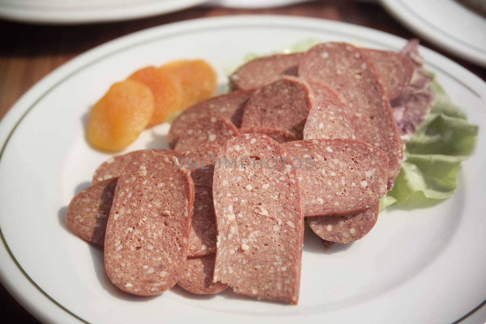close up shot of sliced pepperoni plate on breakfast table