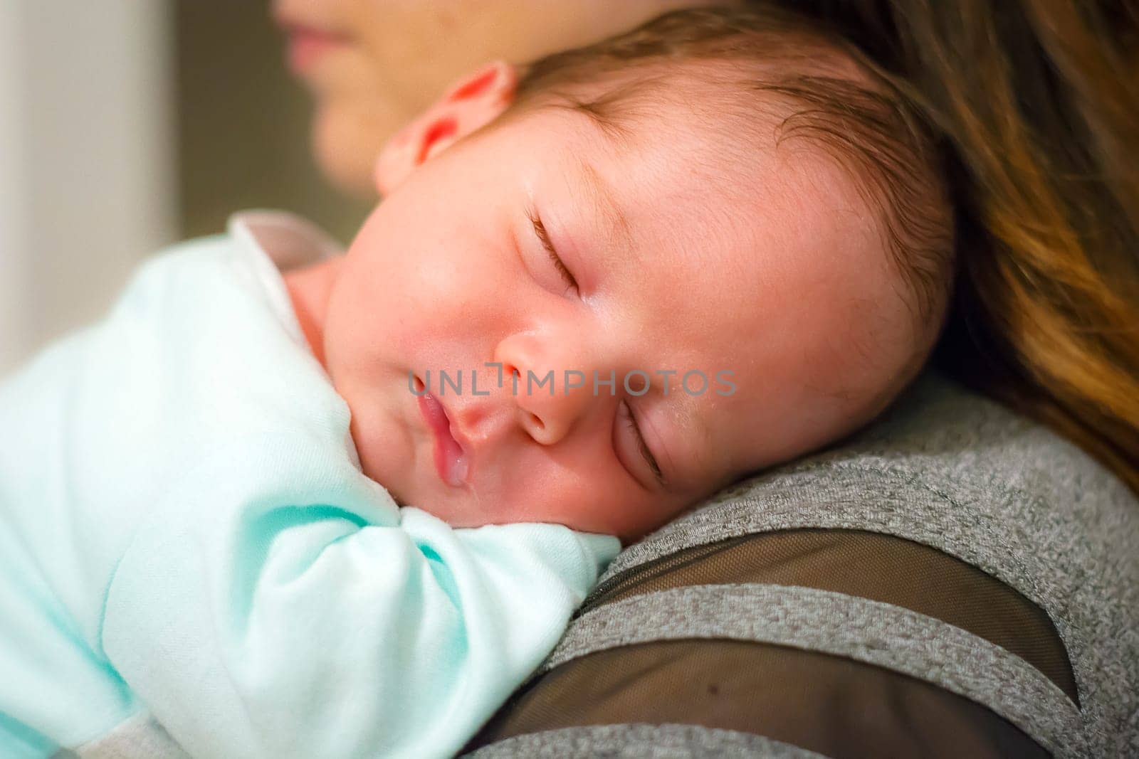 baby sleeping on his mother's shoulder. Family and childhood innocence concept