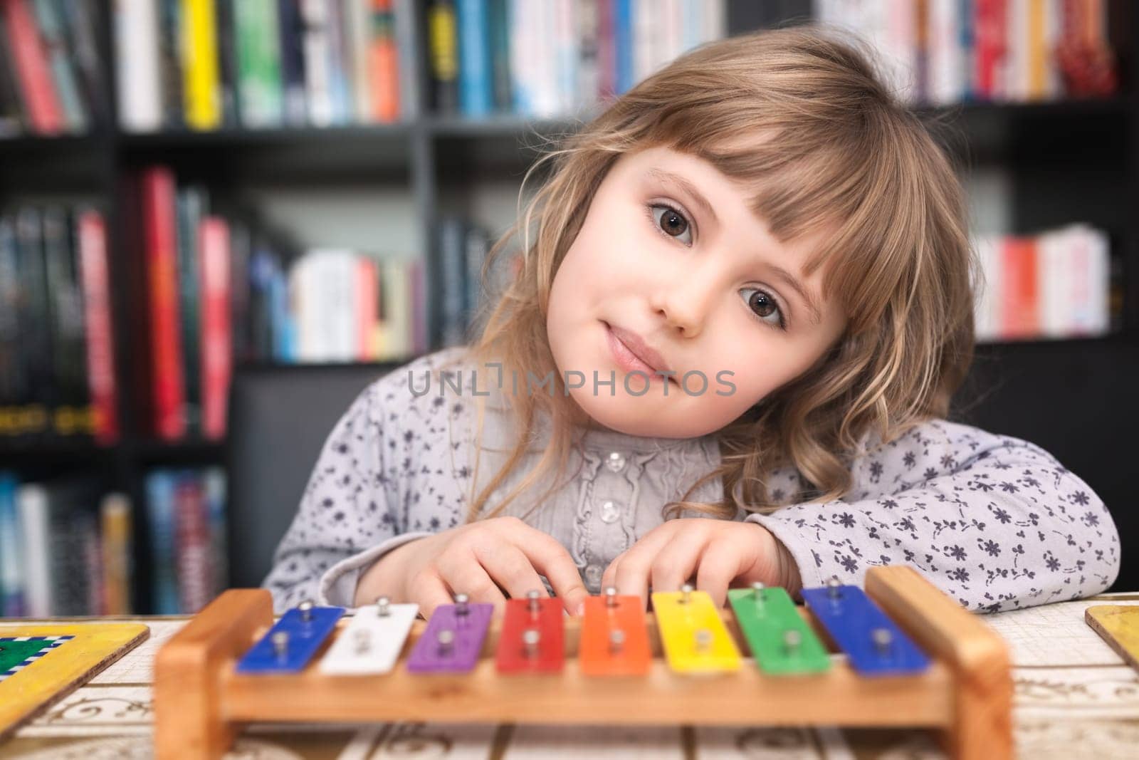 Cute little Caucasian girl playing little colorful cymbals at home