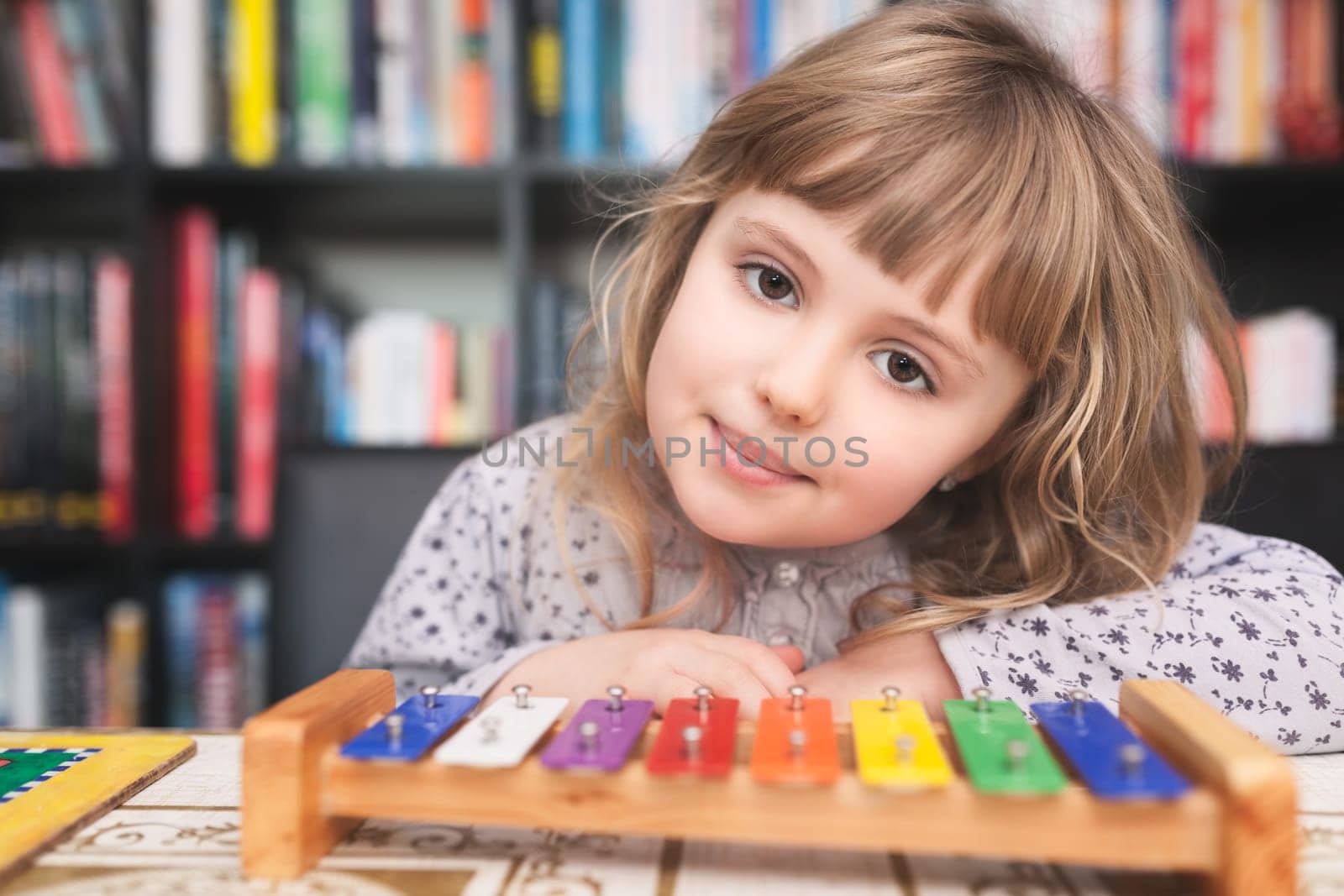 Cute little Caucasian girl playing little colorful cymbals at home