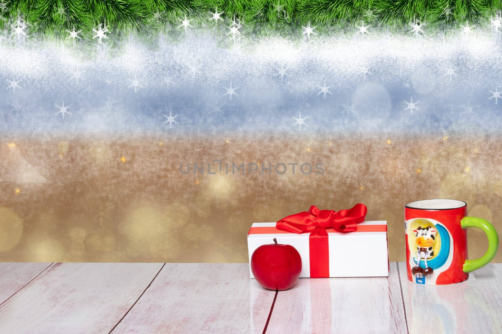Christmas or winter decoration background. Christmas white gift box with an apple and a funny cup on a rustic wooden table. Closeup.