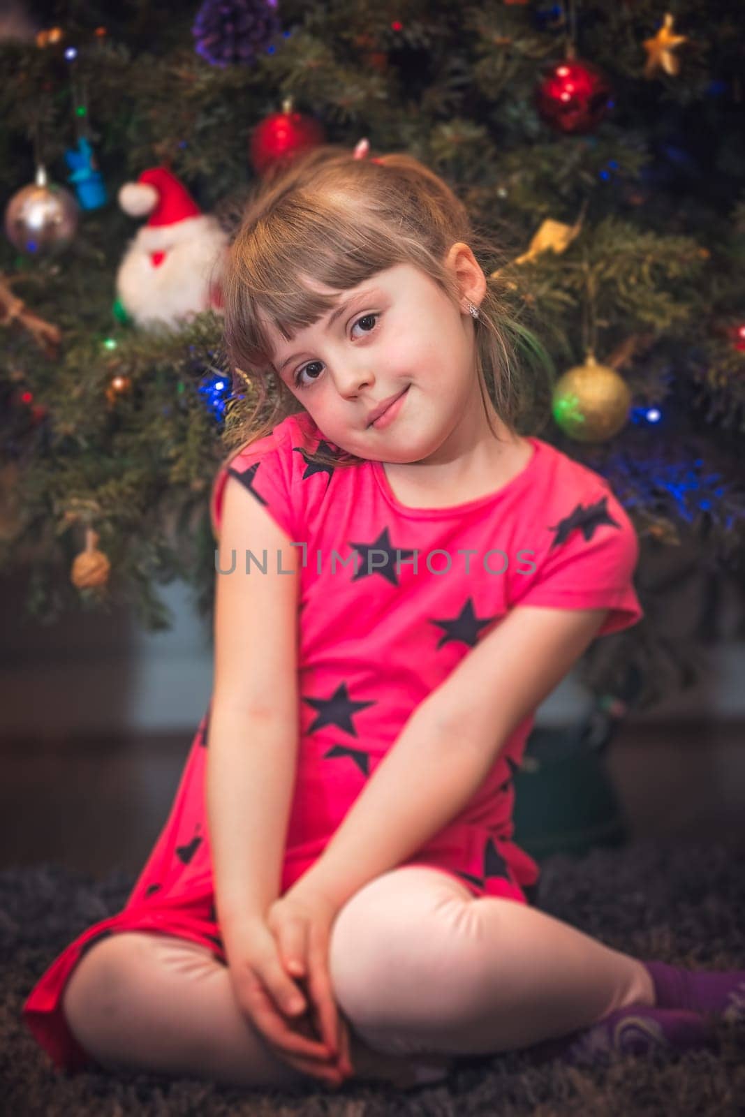 Cute Christmas girl with the Christmas tree lights bokeh in the background