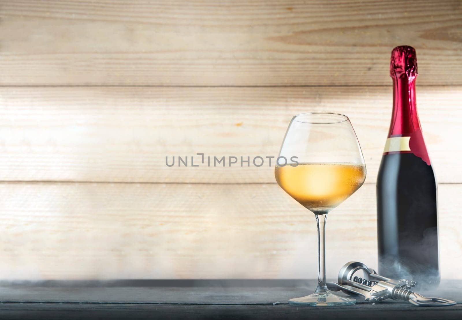 Wine bottle, glasses and corkscrew over wooden background