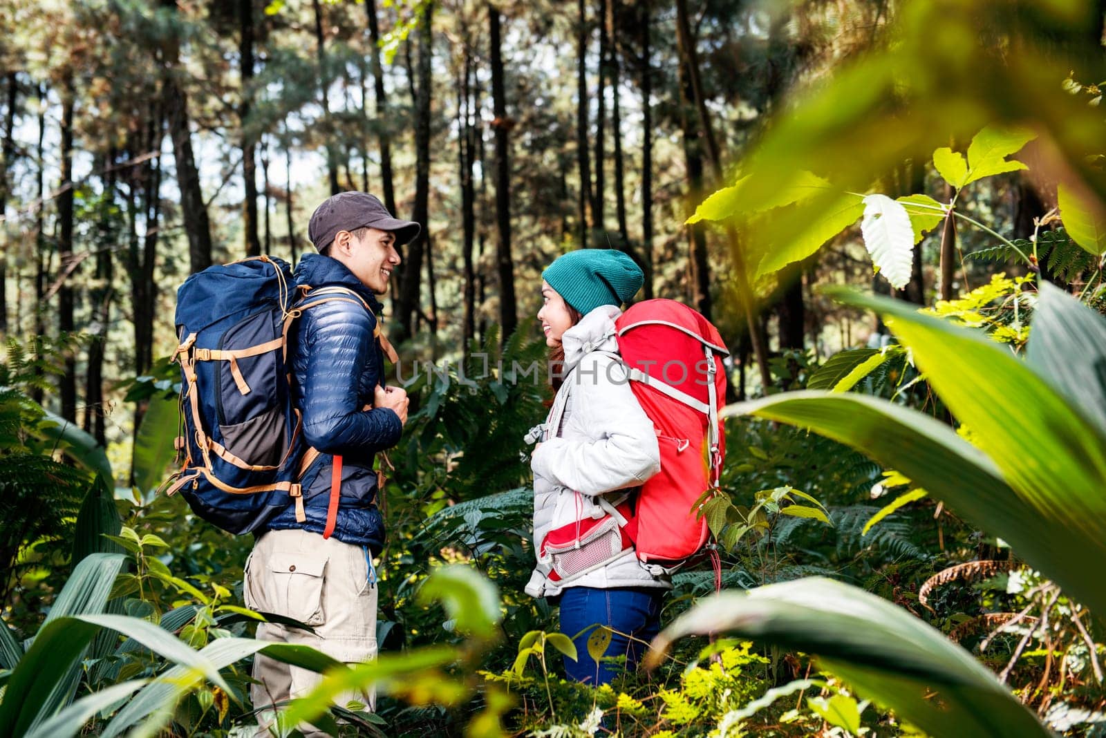 Portrait of asian hikers couple standing and looking each other on the forest