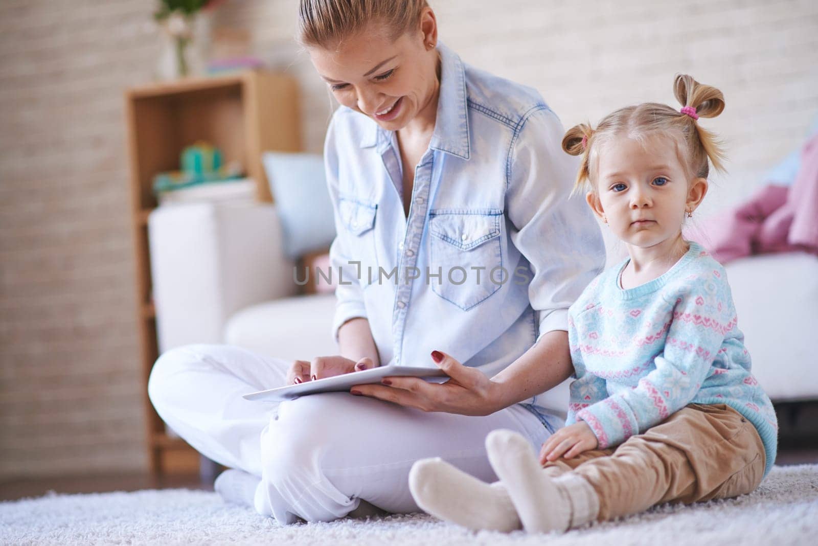 Adorable little girl and her mother spending weekend together at home