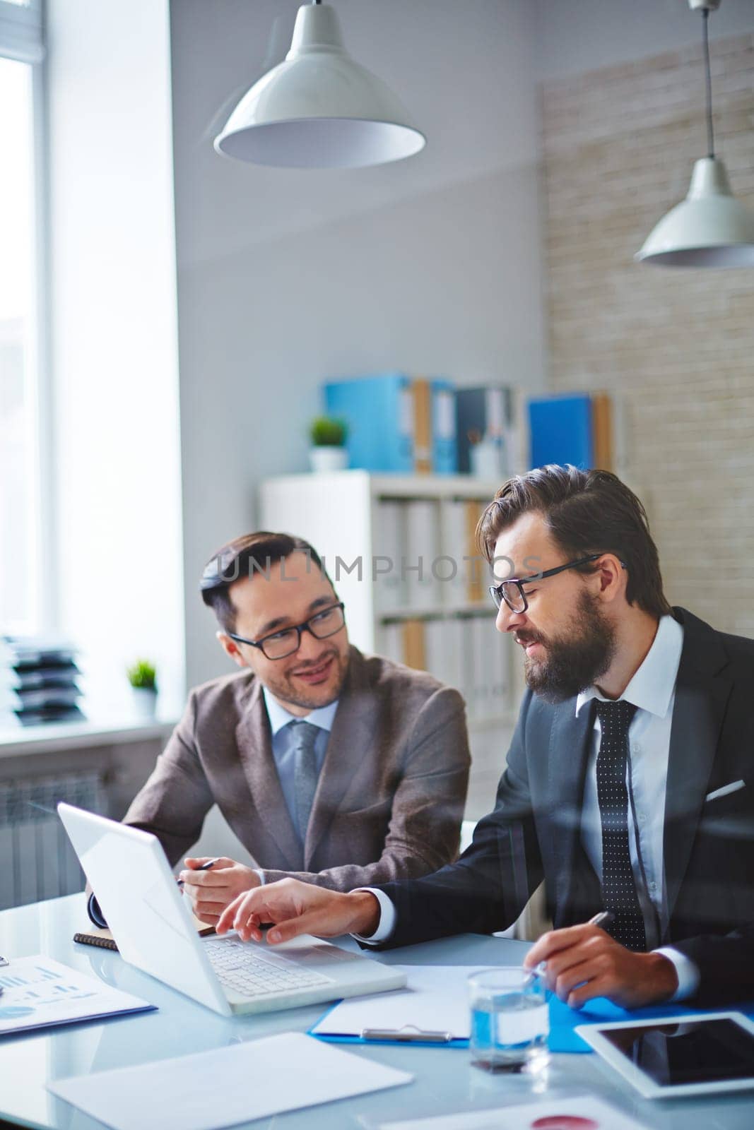 Two confident businessmen brainstorming while planning work
