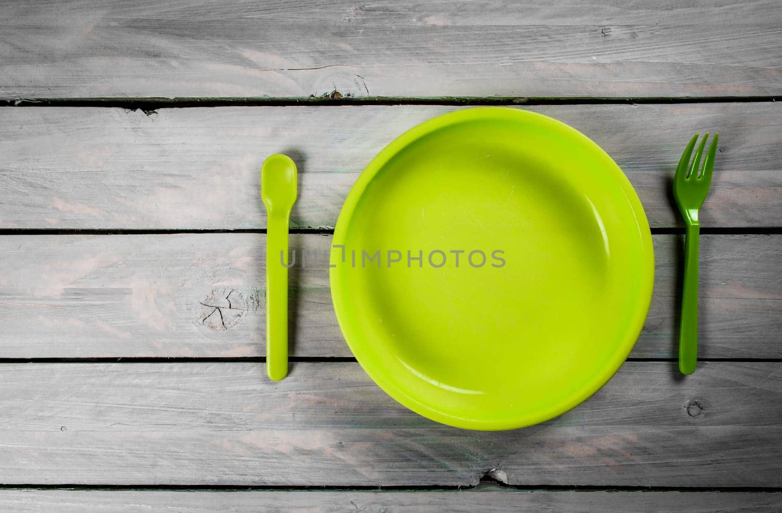Green kids plate on wooden background