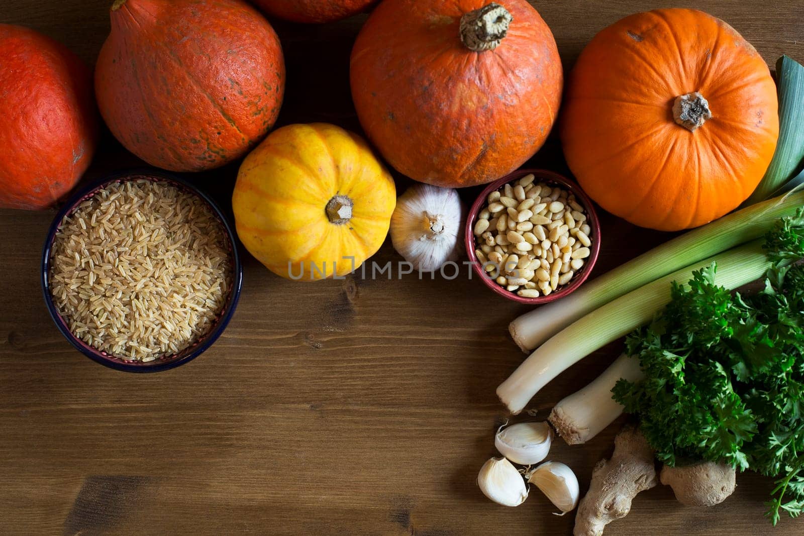 Brown rice, various types of winter squash, leeks , pine nuts and garlic from above with copy space, a healthy eating still life