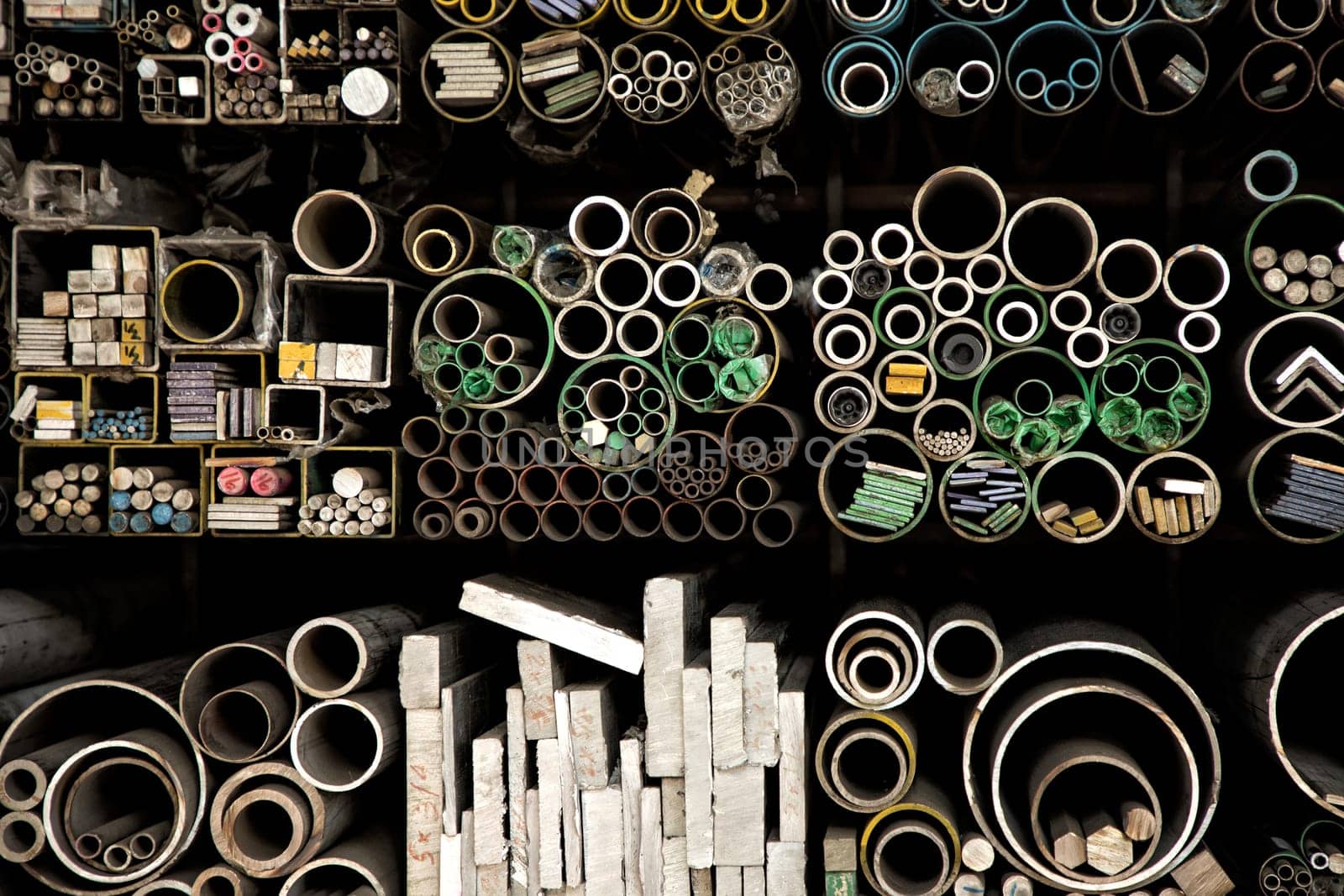 Close up various shape industrial steel products of metal profiles and tubes on warehouse shelf