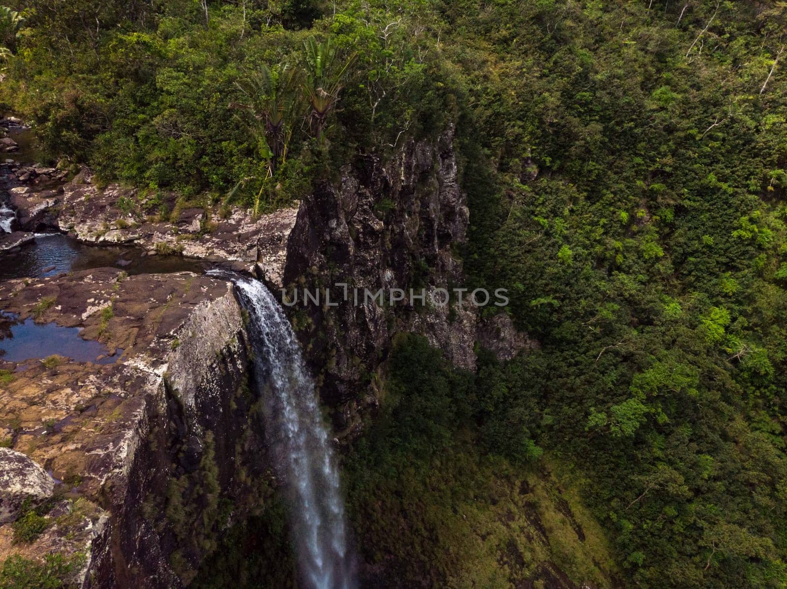 Aerial top view perspective of amazing 500 feet tall annamed waterfall in the tropical island jungle of Mauritius island.