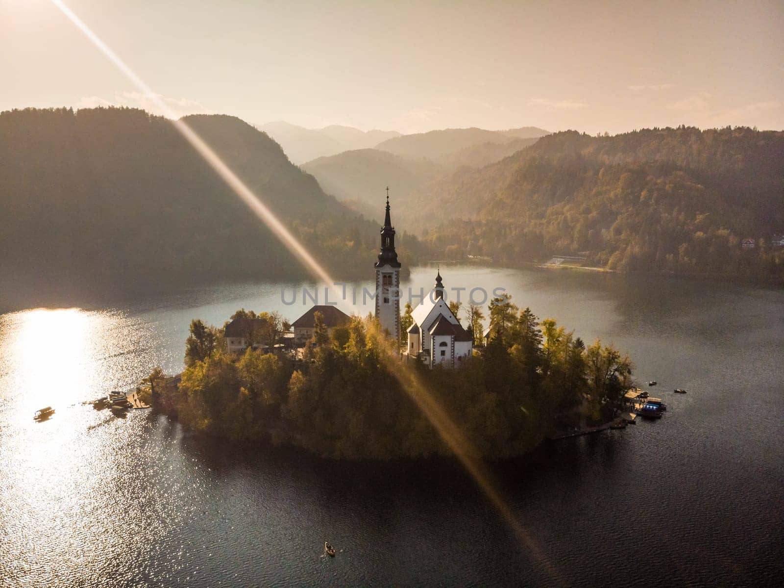 Aerial view of island of lake Bled with Pilgrimage Church of the Assumption of Maria in city of Bled in Slovenia at sunset.