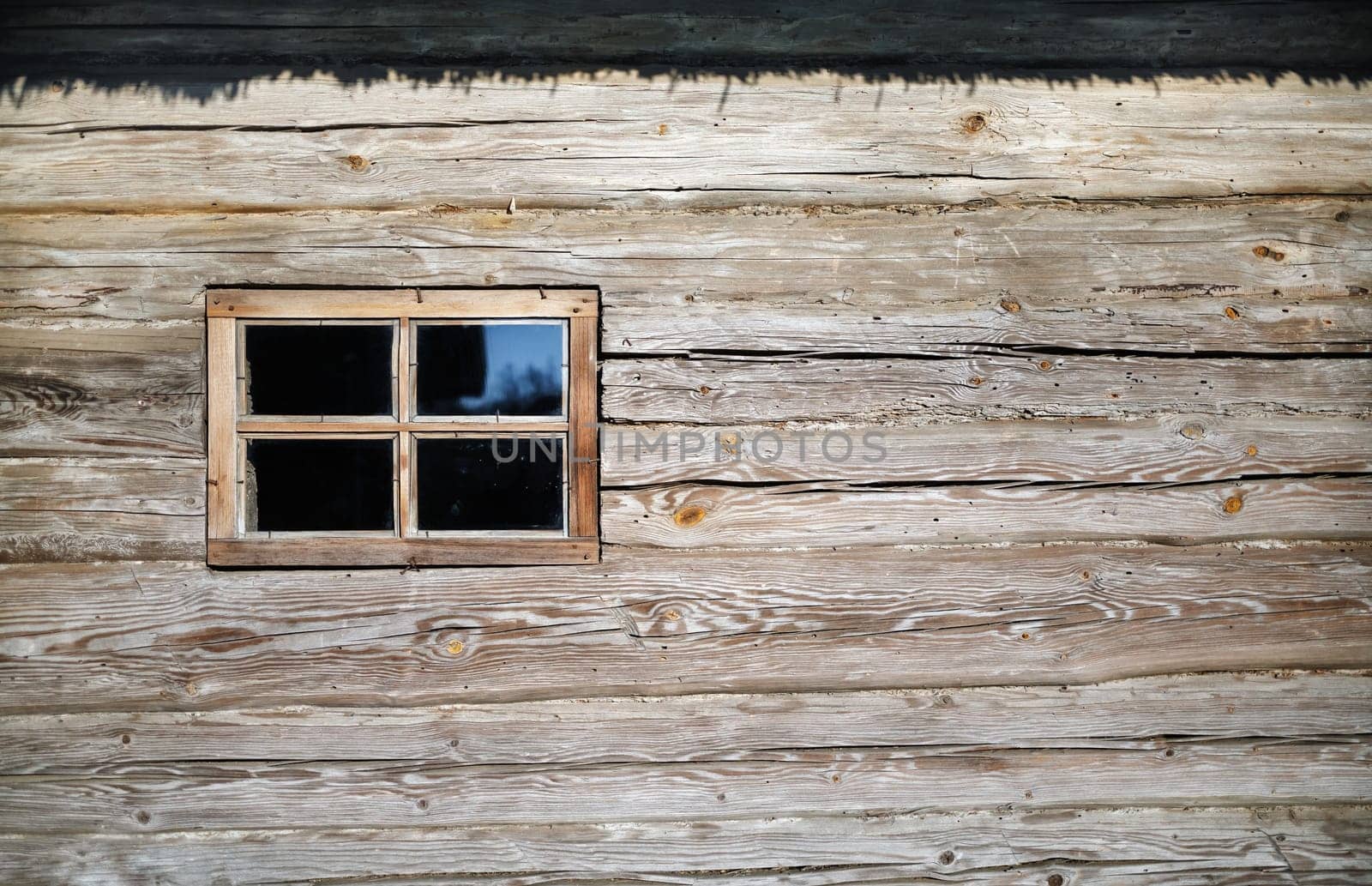 Old wood window on a weathered wooden logs wall. Space for text.