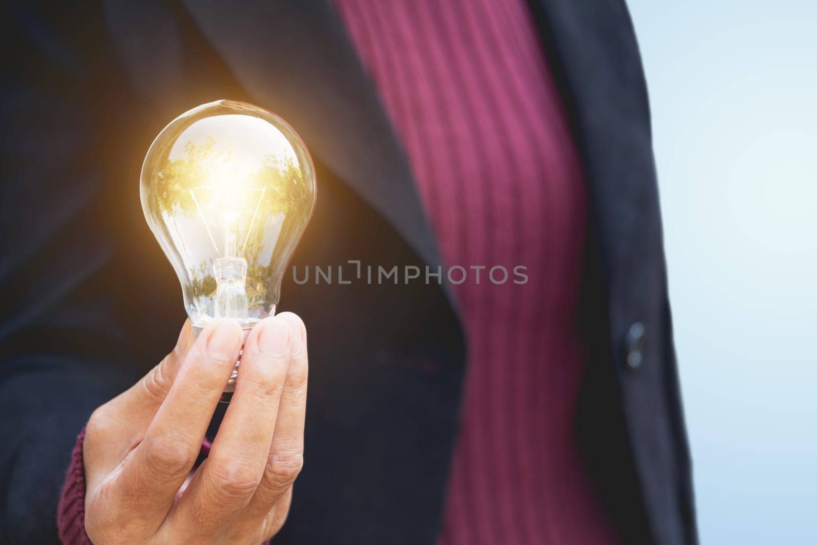 Hand of businesswomean holding light bulb for idea or success or solar energy