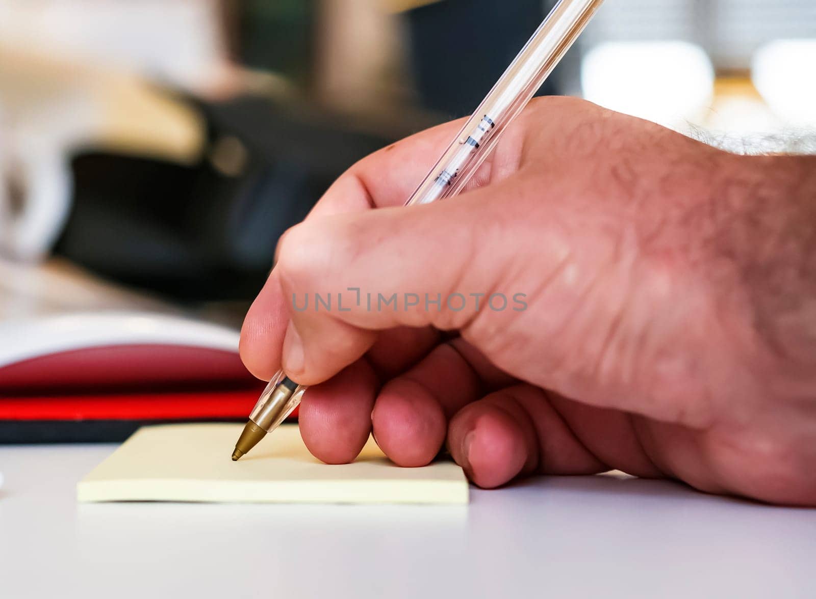 Male hand writing in notebook with pen