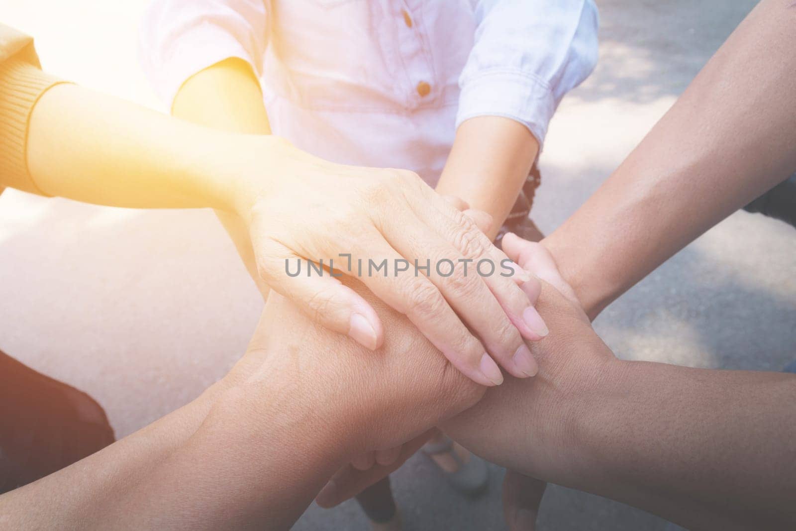 Close up of people putting their hands together. Stack of hands unity and teamwork concept.