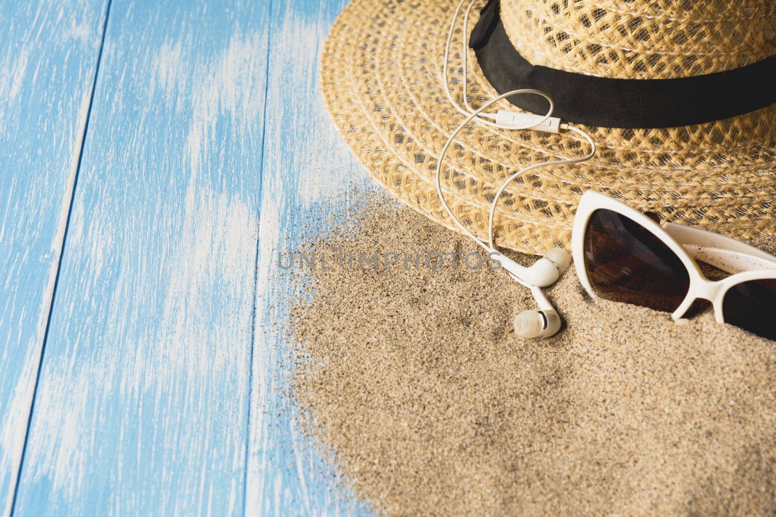 Travel equipment, eyeglasses and sun hat on blue wooden background. Copy space for creative design text and word.