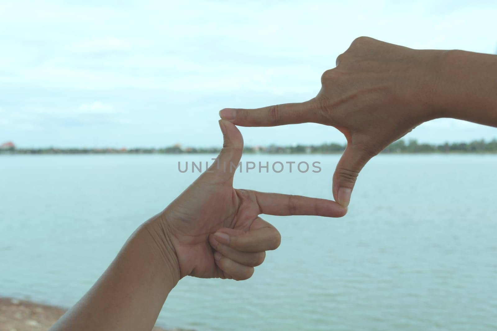 Close up of hands making frame gesture. Close up of woman hands making frame gesture with sunset.