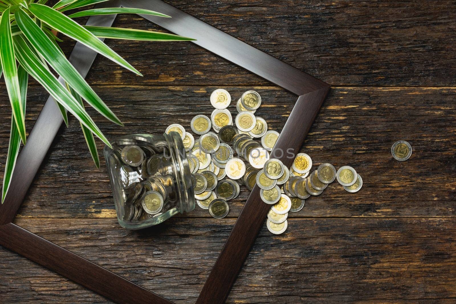 Top view of stack of coin in the frame accounting concept on wooden background.