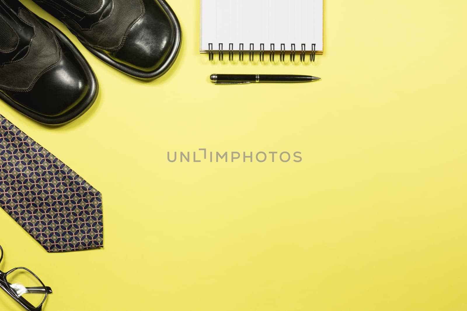 White blank notebook with office supplies on yellow background with copy space for insert text.