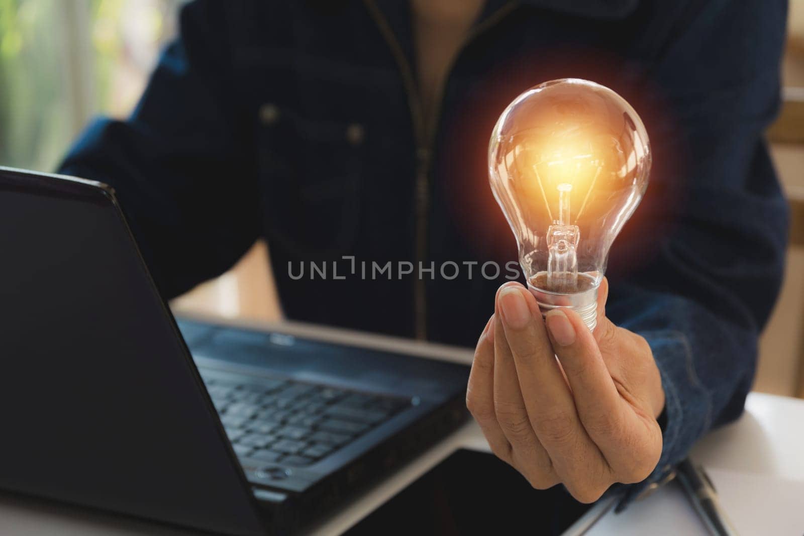 Hand of male holding a light bulb for innovation and creative concept .