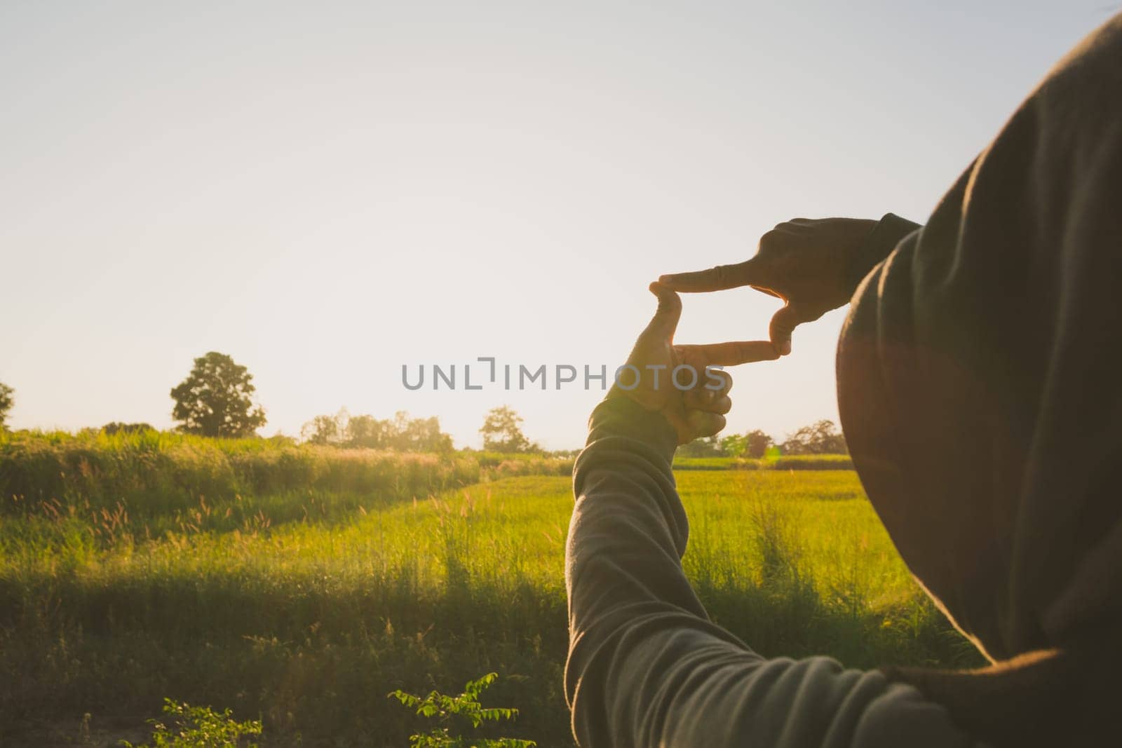 Hands making frame with sunset. Close up of woman hands making frame gesture.
